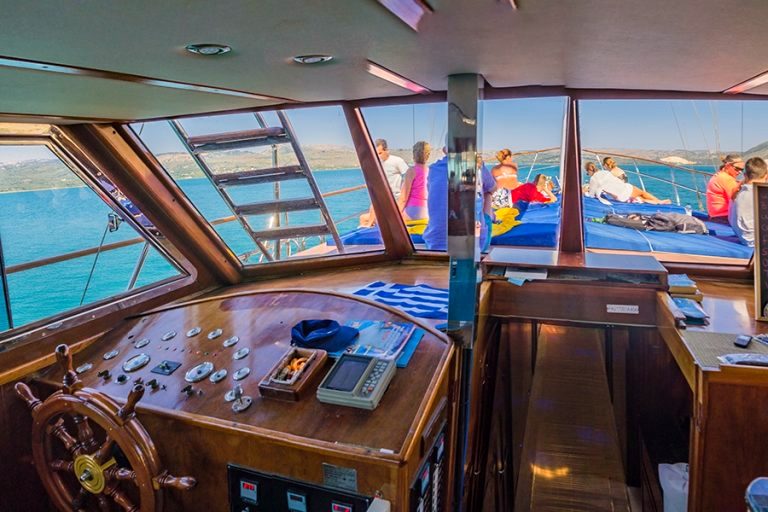 The wooden wheelhouse of Efplia with its spoked wooden helm