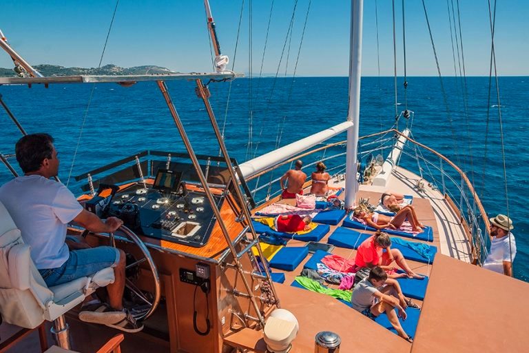 The wide deck of Efplia with the skipper at the wheel