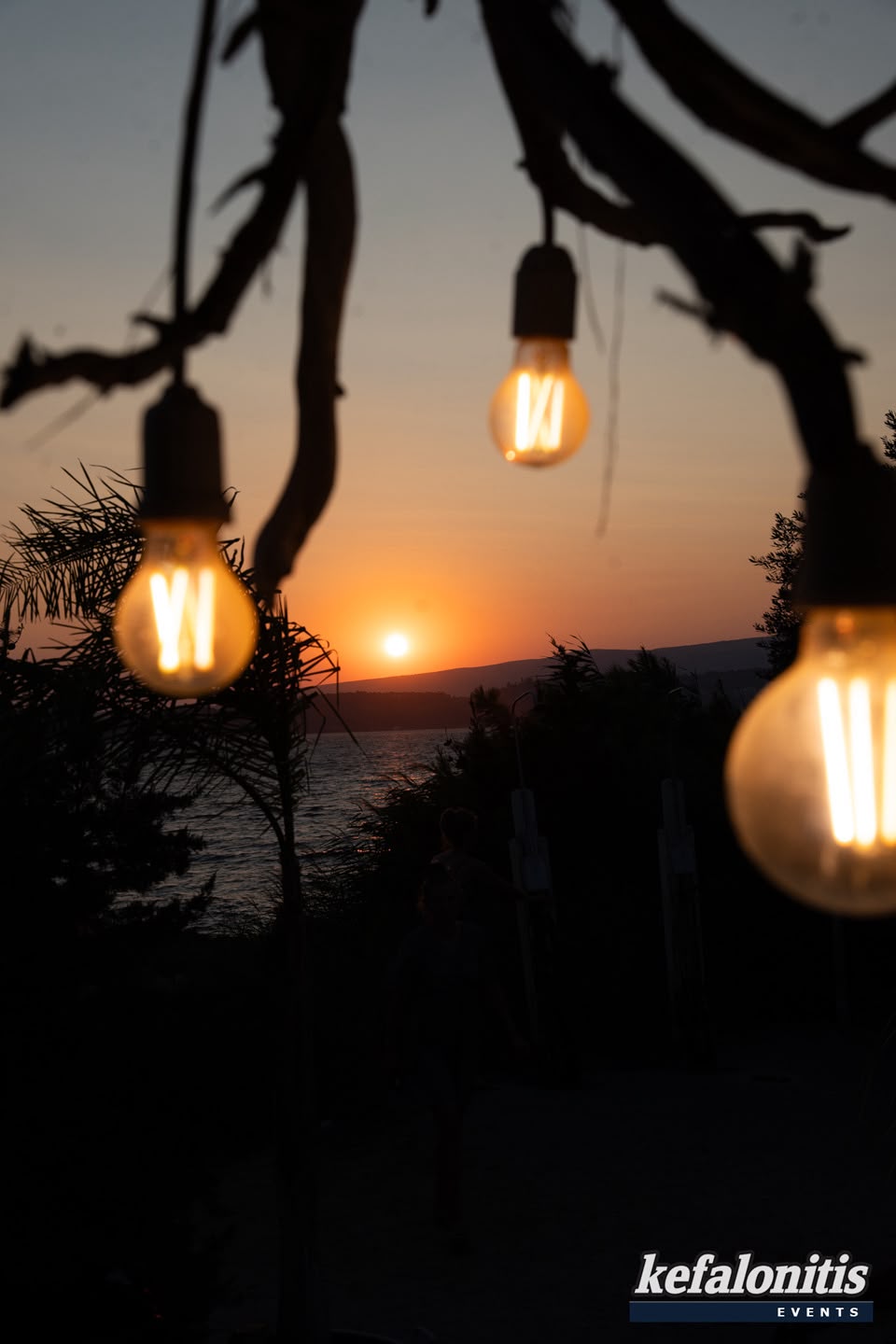 String lights against the sunset over the sea
